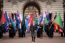 Former British cyclist Sir Chris Hoy (C) leads a procession of Commonwealth flags during the launch of the 2014 Glasgow Commonwealth Games baton relay at Buckingham Palace in London, on October 9, 2013. ©AFP PHOTO/Leon Neal