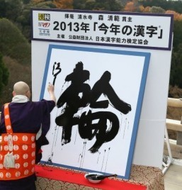 Seihan Mori, the chief priest of Kyoto's famous Kiyomizu temple, displays his caligraphy of a kanji (or Chinese character), "wa" meaning "ring", which was selected as the single best kanji to symbolize the year 2013 at the temple in Kyoto, western Japan on December 12, 2013. ©AFP PHOTO / JIJI PRESS
