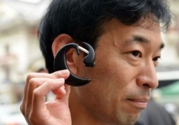 This picture taken on February 20, 2014 shows Japan's Hiroshima University lecturer Kazuhiro Taniguchi showing the "Earclip-type Wearable PC" equipped with a GPS, compass, gyro-sensor, battery, barometer, speaker, microphone and bluetooth wireless communication capability in Tokyo. A tiny personal computer that is worn on the ear and can be controlled with the blink of an eye or the click of a tongue is being tested in Japan. ©AFP PHOTO / Yoshikazu TSUNO
