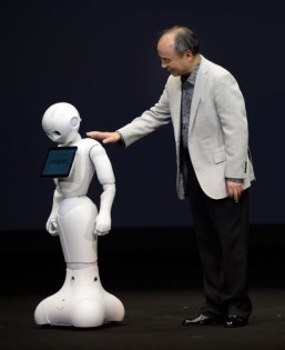 Masayoshi Son (R), president of Japan's mobile carrier SoftBank, consoles humanoid robot 'Pepper' (L) equipped with an emotion engine during a press conference in Urayasu, suburban Tokyo, on June 5, 2014. Softbank will release the robot next February with a price of USD 1,980 (198,000 yen). ©AFP PHOTO / Toru YAMANAKA