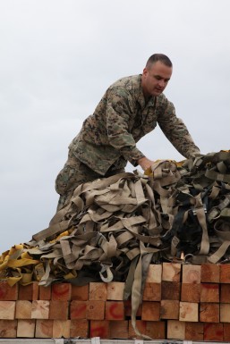 A U.S. Marine uses cargo nets to secure a load of palletized equipment on a KC-130J Hercules aircraft at Marine Corps Air Station Futenma, Okinawa, Japan, during preparation for a humanitarian assistance and disaster relief mission to the Philippines in the wake of Typhoon Haiyan, Nov. 11, 2013. The Marines are assigned to the 3rd Expeditionary Force. U.S. Marine Corps photo by Lance Cpl. David N. Hersey