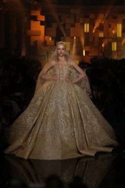 Elie Saab - Haute Couture - fall/winter 2015-2016 Gold sleeveless gown fully embroidered with large floral leaf appliques with silk thread and sequins, a voluminous full skirt and long train, paired with a long embroidered veil ©Elie Saab