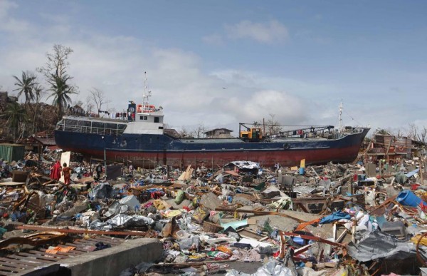 A large boat sits on top of destroyed homes after it was washed ashore by strong waves caused by Typhoon Haiyan, in Tacloban city, Leyte province central Philippines on Sunday, Nov. 10, 2013. Typhoon Haiyan, one of the strongest storms on record, slammed into six central Philippine provinces Friday leaving a wide swath of destruction and hundreds of people dead.(MNS photo)
